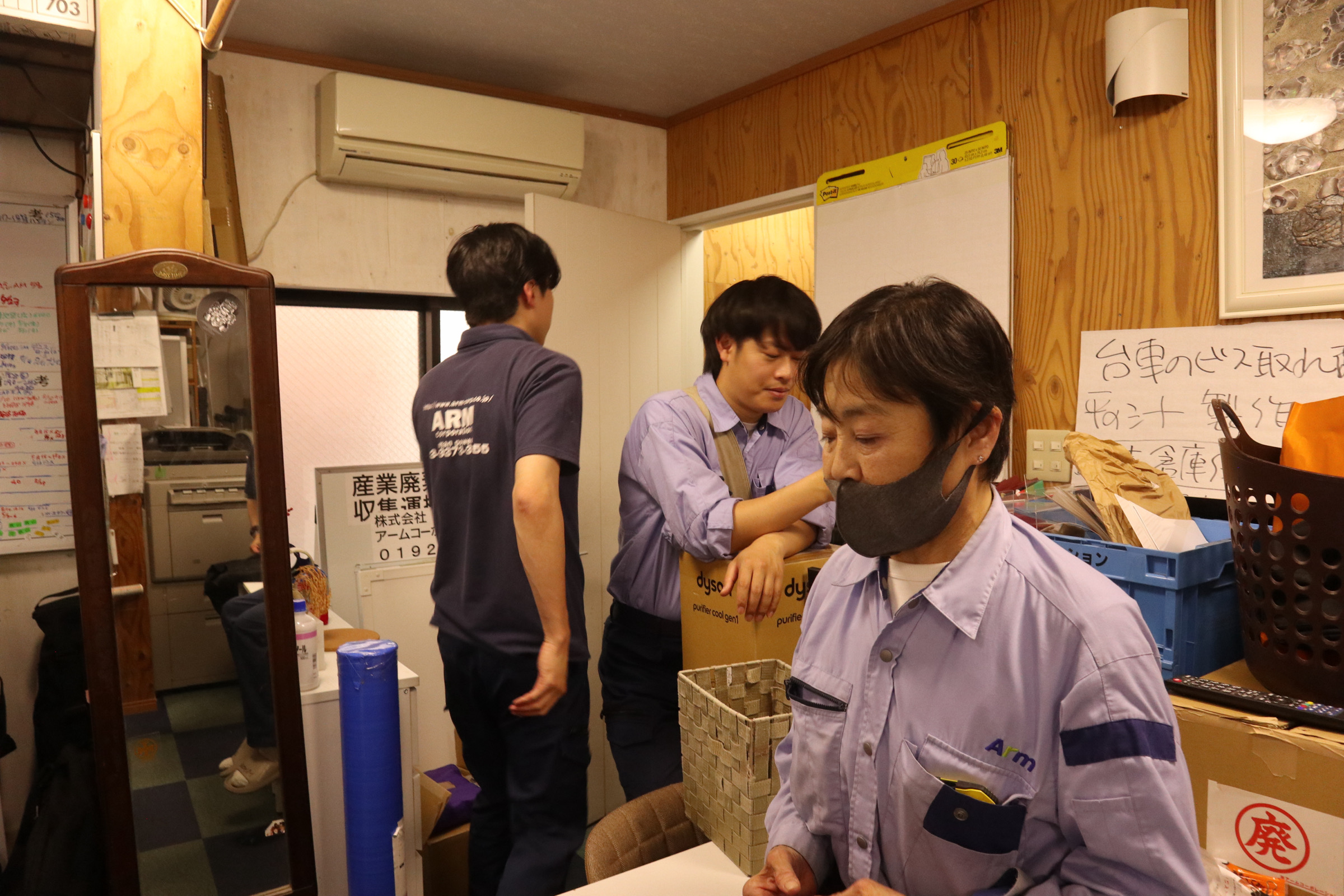 事務所で会話する3名のスタッフ